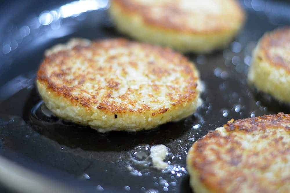 Golden Brown Cauliflower Fritters frying in a pan