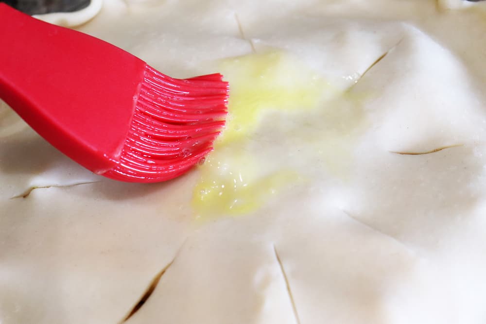 Brushing pie dough with melted butter
