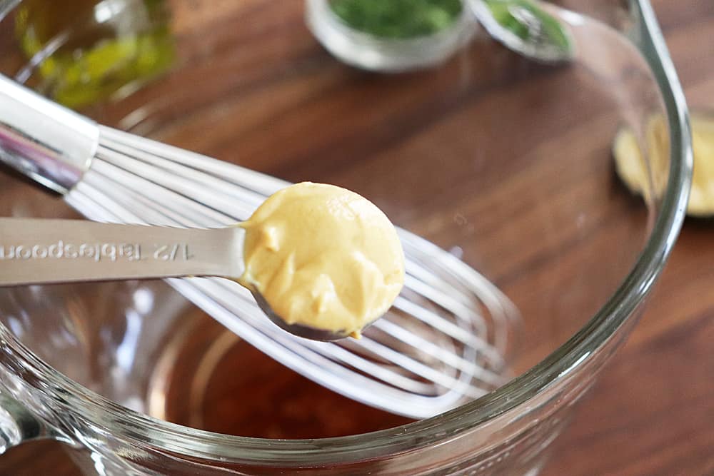Dijon mustard in a measuring spoon for Warm Potato Salad with Dijon Vinaigrette
