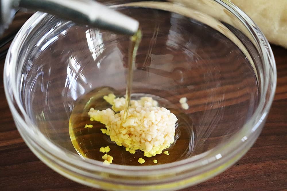 adding olive oil to minced garlic