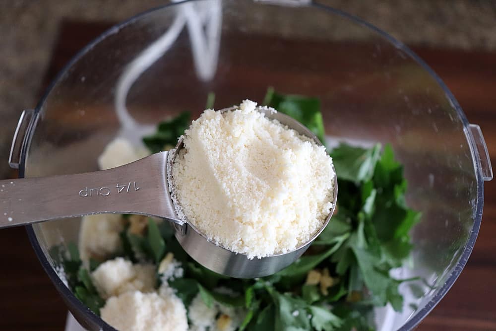 Adding parmesan to parsley in a food processor