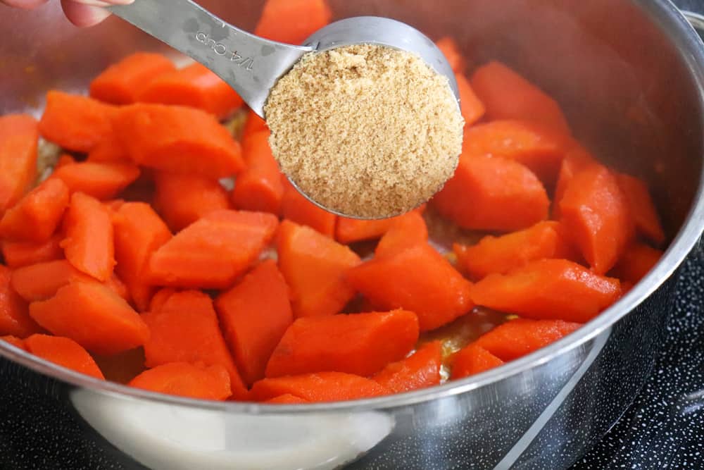 Adding brown sugar and water to carrots
