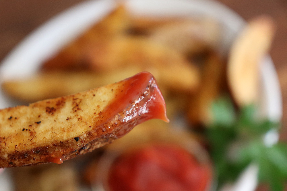 Bite shot of Crispy Baked Potato Wedges